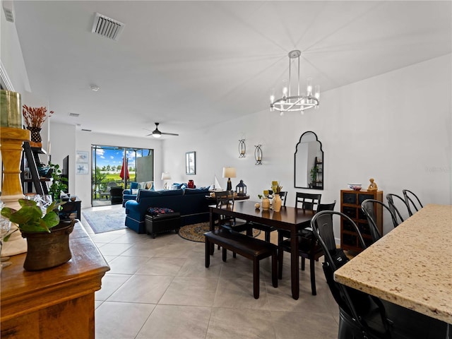 dining space featuring light tile patterned floors, ceiling fan with notable chandelier, and visible vents