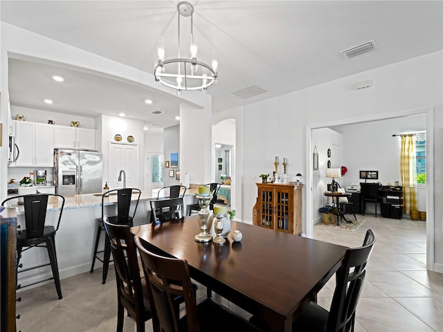 tiled dining space with a notable chandelier