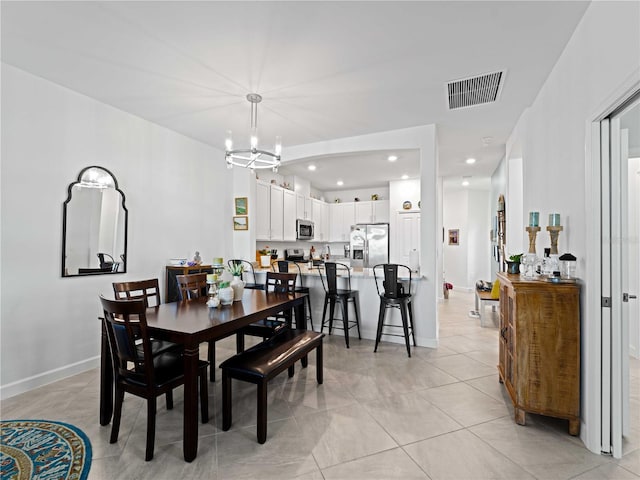 tiled dining space with a chandelier