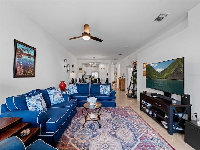 living area with ceiling fan with notable chandelier, visible vents, and light tile patterned floors