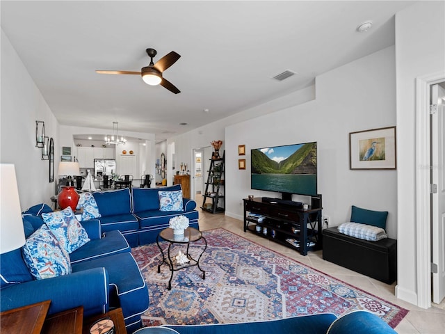 living room with light tile patterned floors, visible vents, and ceiling fan with notable chandelier