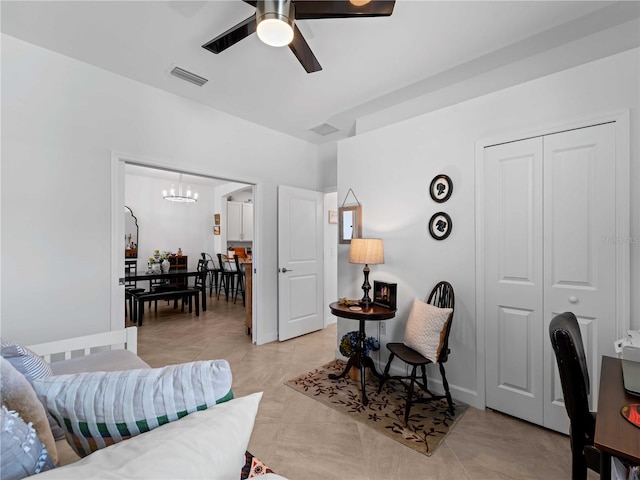 living room featuring ceiling fan with notable chandelier and light tile patterned floors