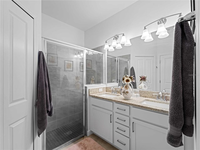 full bathroom featuring double vanity, a sink, and a shower stall