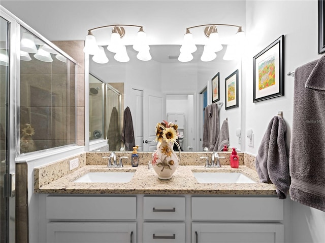 bathroom featuring a sink, a shower stall, and double vanity