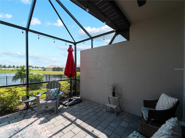 view of patio / terrace with a lanai and a water view