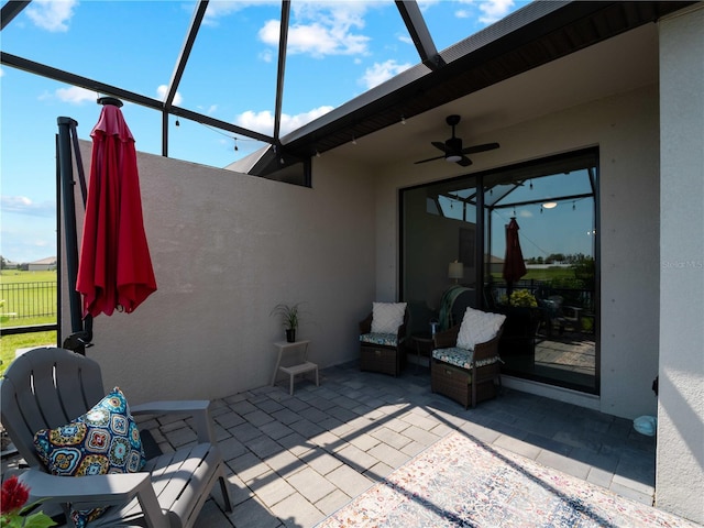 view of patio / terrace featuring ceiling fan and a lanai