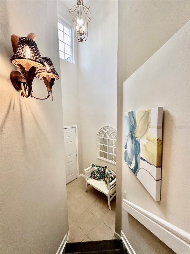 corridor with light tile patterned flooring and a chandelier