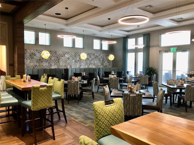 dining area featuring wood finished floors and a towering ceiling