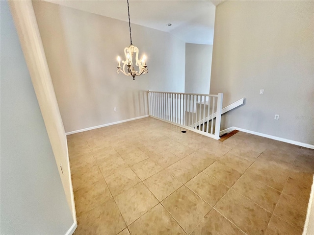 spare room featuring tile patterned flooring and an inviting chandelier