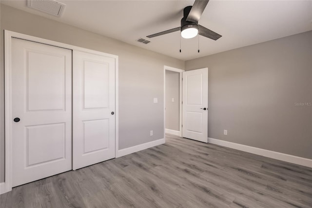 unfurnished bedroom featuring light wood-type flooring, a closet, and ceiling fan