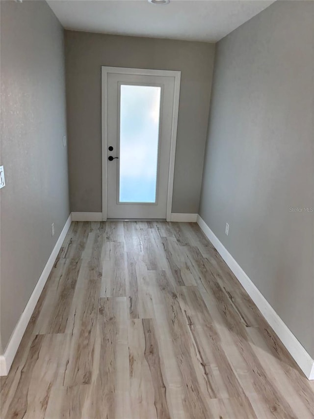 spare room featuring baseboards and wood finished floors