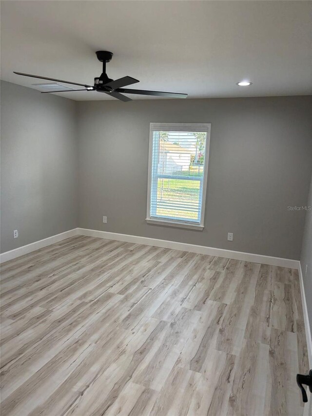 empty room with recessed lighting, light wood-style floors, a ceiling fan, and baseboards