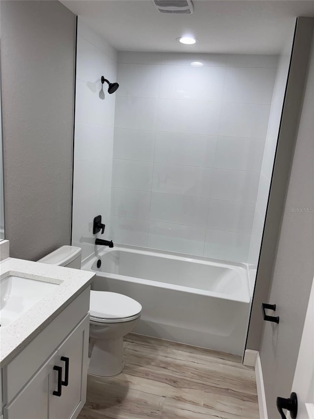 full bathroom with shower / bath combination, wood finished floors, vanity, and toilet