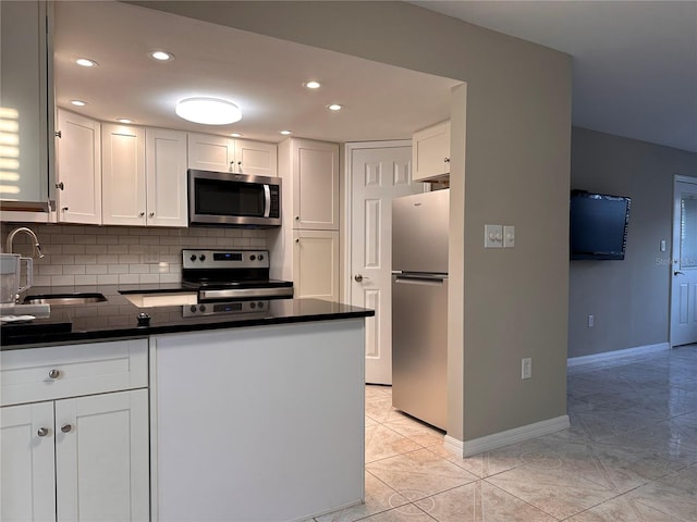 kitchen with sink, decorative backsplash, white cabinetry, and appliances with stainless steel finishes