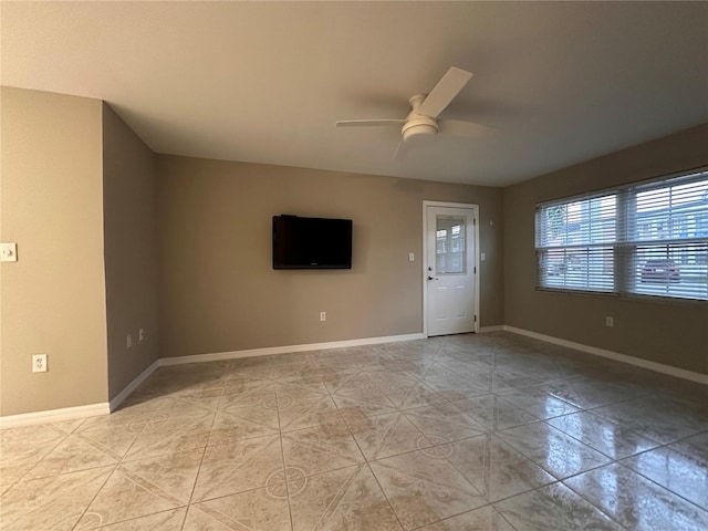 empty room with ceiling fan and light tile patterned floors