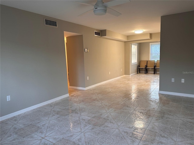 tiled spare room featuring ceiling fan