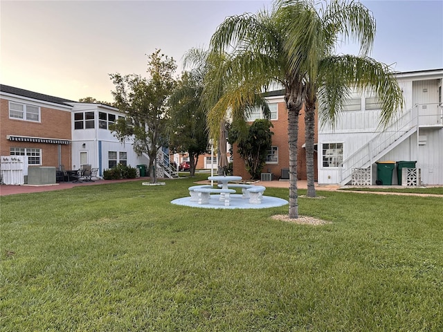 yard at dusk with central AC unit