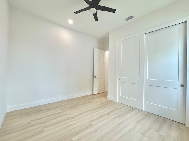 unfurnished bedroom featuring light hardwood / wood-style floors, ceiling fan, and a closet