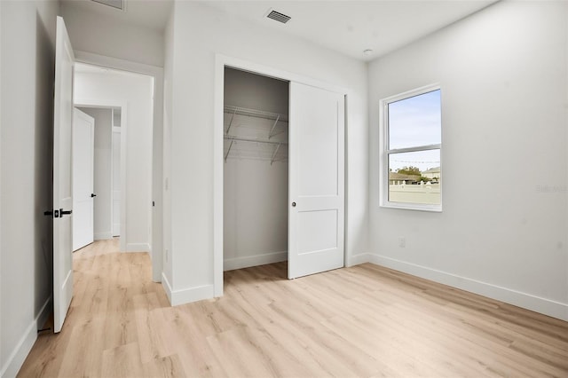 unfurnished bedroom featuring light wood-type flooring and a closet