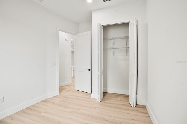 unfurnished bedroom featuring a closet and light wood-type flooring