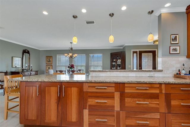 kitchen with ornamental molding, light stone counters, hanging light fixtures, and a notable chandelier