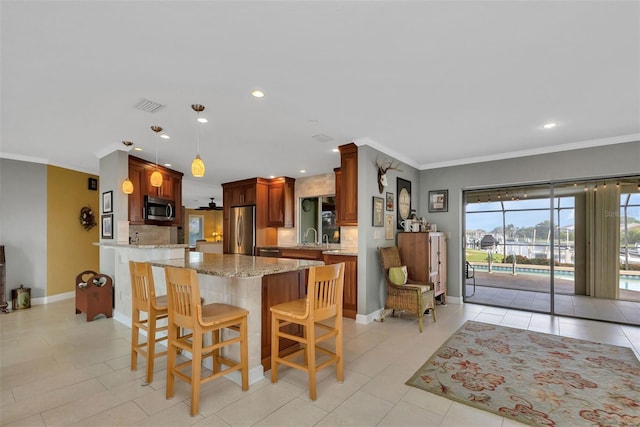 kitchen with tasteful backsplash, light stone counters, decorative light fixtures, appliances with stainless steel finishes, and ornamental molding