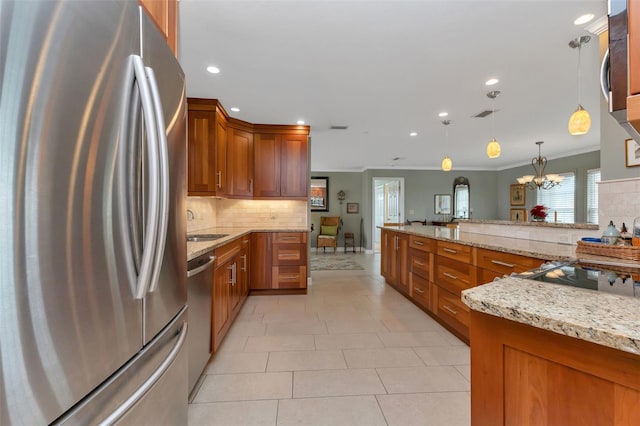 kitchen featuring pendant lighting, crown molding, light stone countertops, appliances with stainless steel finishes, and a notable chandelier