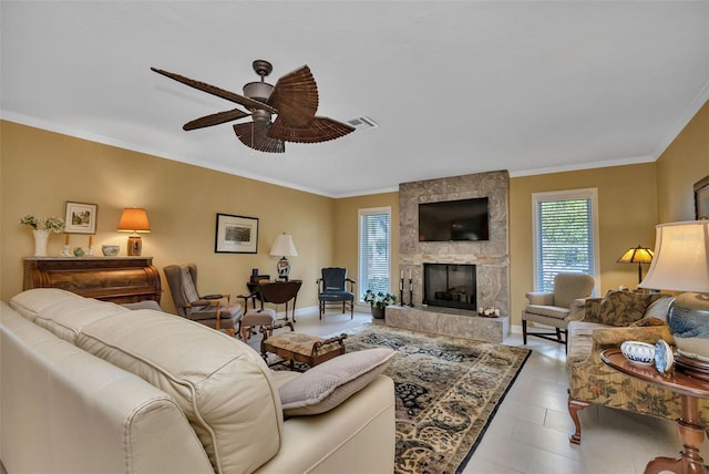 living room featuring ceiling fan, a large fireplace, light tile patterned flooring, and ornamental molding