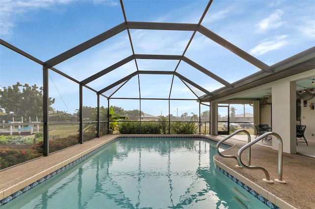 view of swimming pool featuring glass enclosure and a patio area