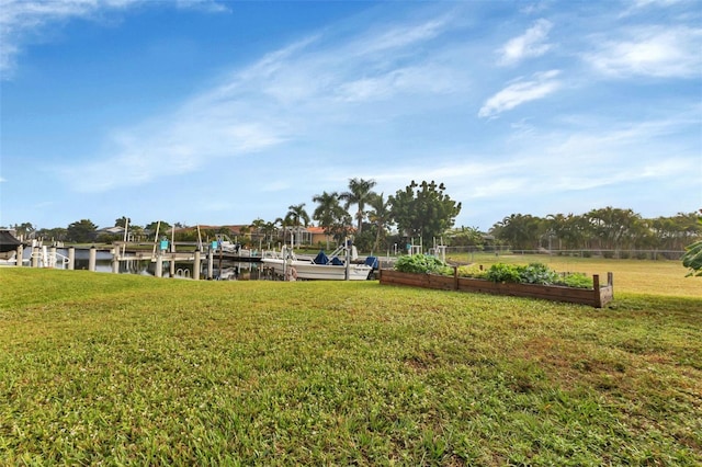 view of community with a water view, a yard, and a dock