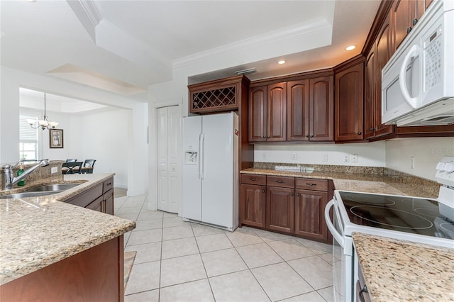 kitchen with a raised ceiling, sink, a chandelier, and white appliances