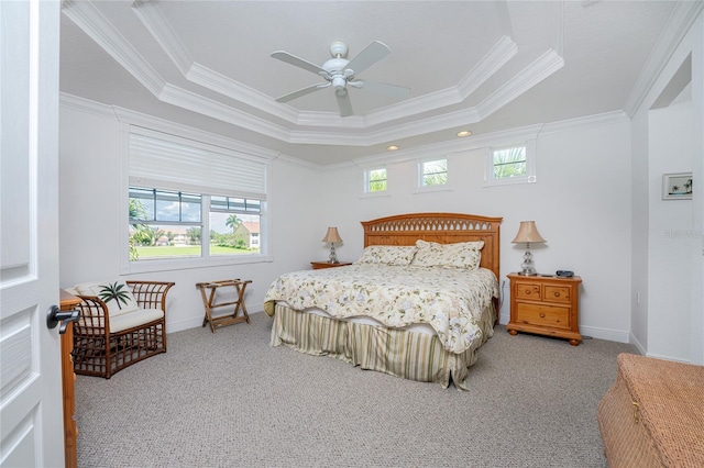 carpeted bedroom with a tray ceiling, ceiling fan, and crown molding