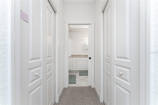 hallway featuring ornamental molding and light carpet