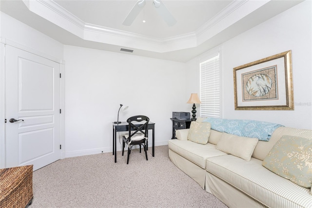 living room with a tray ceiling, light carpet, crown molding, and ceiling fan