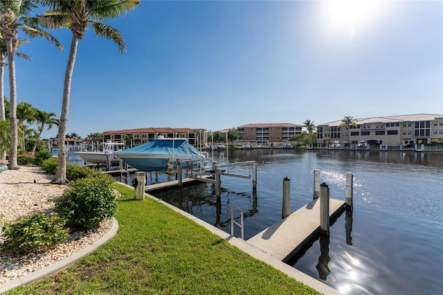 dock area with a water view and a lawn