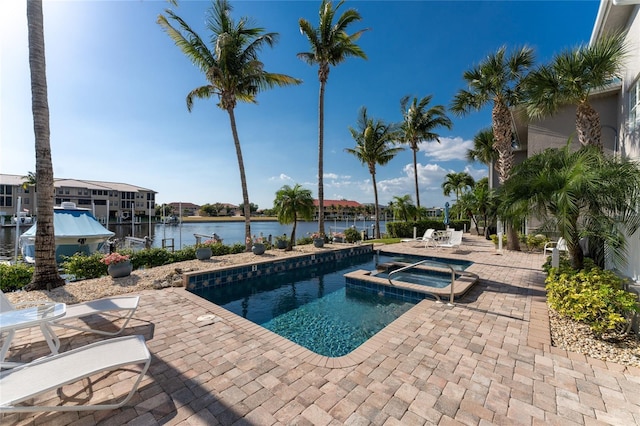 view of pool with an in ground hot tub, a patio, and a water view