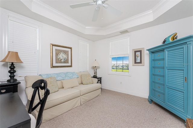 carpeted living room featuring a raised ceiling, ceiling fan, and ornamental molding