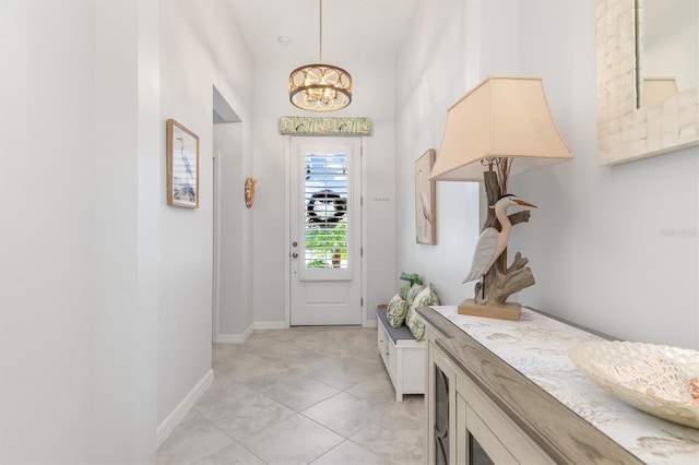 tiled entrance foyer with an inviting chandelier