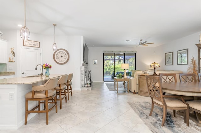 dining space featuring ceiling fan and sink