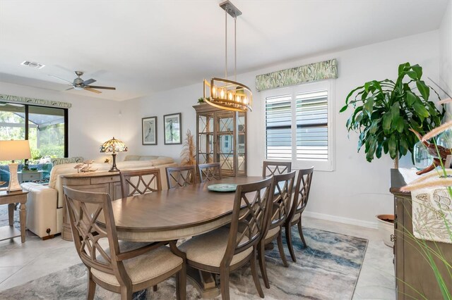 tiled dining space with ceiling fan with notable chandelier and a wealth of natural light