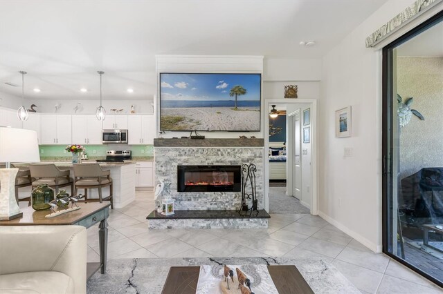 tiled living room with a stone fireplace