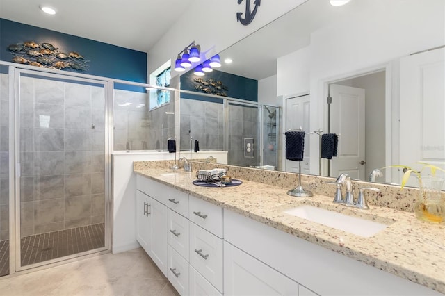 bathroom with tile patterned flooring, vanity, and walk in shower