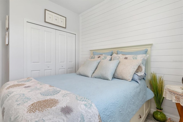 bedroom with a closet and wood walls