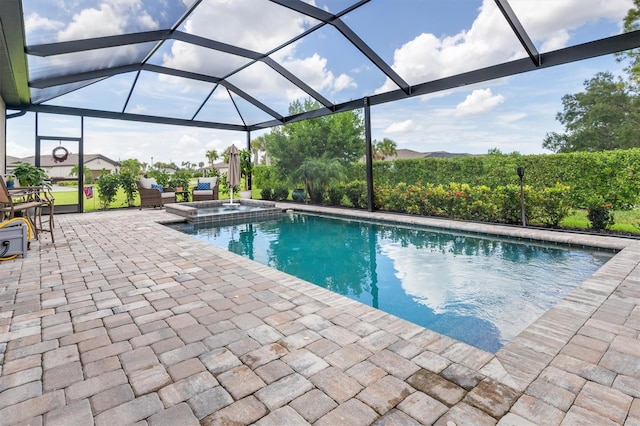 view of swimming pool featuring glass enclosure, a patio area, and an in ground hot tub