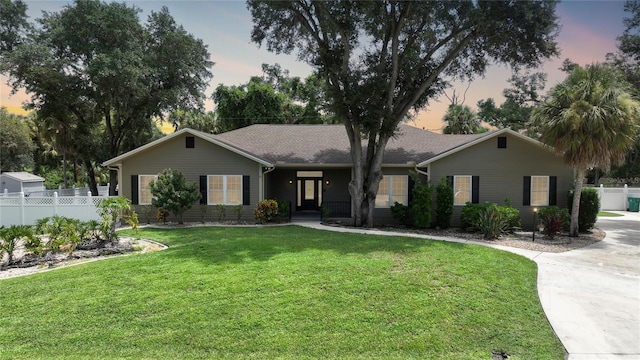 single story home featuring a yard and fence