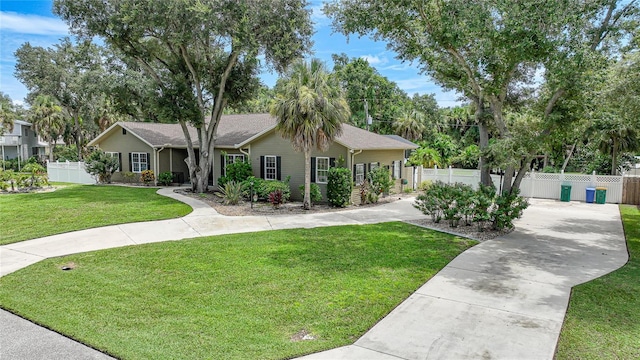 ranch-style house featuring fence, driveway, and a front lawn