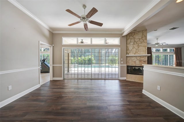 unfurnished living room with ceiling fan, crown molding, a stone fireplace, and dark hardwood / wood-style flooring