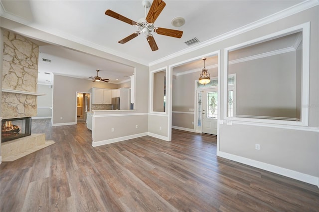 unfurnished living room featuring visible vents, a fireplace, and wood finished floors