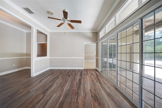 empty room with plenty of natural light, visible vents, dark wood-type flooring, and ornamental molding