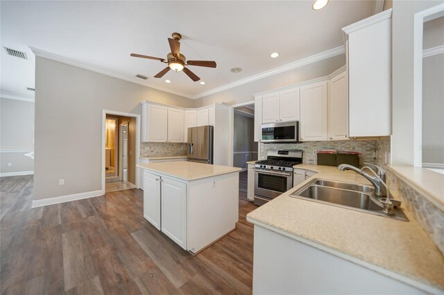 kitchen with stainless steel appliances, decorative backsplash, sink, wood-type flooring, and ceiling fan